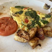 Veggie omelette with Just egg and vegan cheese, homestyle potatoes and tomato slices  at Global Cafe  in Lawrence