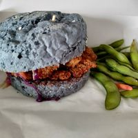 Butterfly pea bun filled with coleslaw and battered mushroom at SoyGreen in San Salvador
