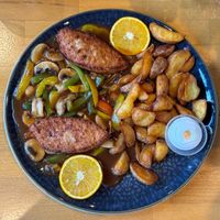 Chicken style schnitzel in brown sauce with potato  wedges at Ronja in Muelheim