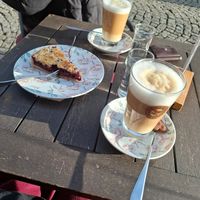 Kirsch-Streuselkuchen und Latte Machiatto mit Hafermilch (02/2025) at Cafe Baumgarten in Fuessen