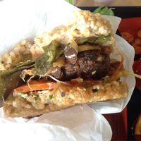 Natto burger with rice-'bun' and a couple bites taken out of it. at Tama Organic Life in Vancouver