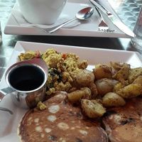 Choc chip & caramelized banana pancakes, tofu scramble, and home fries. at Cosmic Treats in Toronto