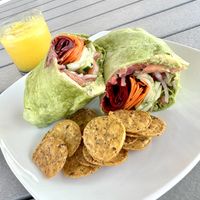 Veggie delight wrap with fresh veggies, avocado and hummus. The chips and juice are my own.   at Juicebox in Ocean View