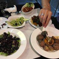 Olives, guacamole, vegan sausages, sun dried tomatoes, canary island potatoes  at The Mantraa in Barcelona