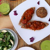 The veggie burger with ratatouille salasa, apple side salad and fresh green juice. at El Karmem in Malaga