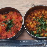 (Vegan tiffin box for one) left to right: Ginger and rhubarb dahl, picnic potato curry, tea steeped chickpeas and rice. at Mowgli in Manchester