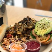Sweet potato quinoa burger. Topped with avocado, sprouts, tomato, spinach, and mushrooms/ onions. Served with fresh slaw covered in a ginger coconut dressing and a delicious house made beet ketchup! at Wild Rabbit Cafe and Health Bar in Flagler Beach