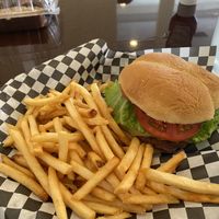 Behind meat burger with pepper jack cheese and friessss ❤️🌱 at Clovermint Cafe and Market in Dania Beach