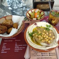 2 types of falafel, pickles, green tea and hummus topped with foul. at Abo Shariha in Doha