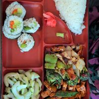 Bento Box: Tofu with hot garlic sauce, vegetable roll, cucumber salad, and white rice at Xin Bowl in Ridgecrest