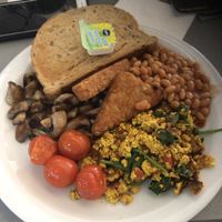 Full sized vegan breakfast with scrambled tofu, mushrooms, tomatoes, hash browns, beans and toast with spread at Phoenix Cafe Bar in Leicester