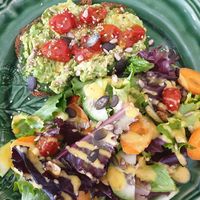 Avocado pesto cherry tomatoes toast with side salad tasty at Dona Flor Cafe in Cascais