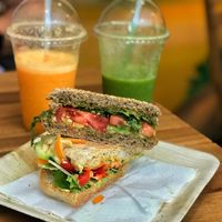 Pesto Arugula & hummus veggie sandwiches, get orangey  & green smile smoothies at Milk Away in Sevilla