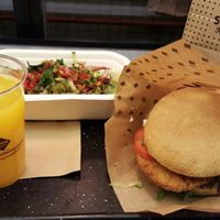Burger with a side of salad and freshly squeezed oj at Swing Kitchen - Operngasse in Vienna
