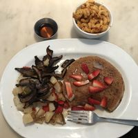Vegan pancakes with fresh strawberries & warm maple syrup, potatoes with peppers & onions, mushroom sausages, & side order is Mac’n cheese!  at Gnome Cafe in Charleston