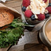 Avocado on a sesame seeded bun with cashew cream cheese and some greenery. Then overnight oats wirh blueberries and raspberries with raw peanut butter. A filter coffee with oatly b at Mahalo - Hornsgatan in Stockholm