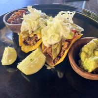 Jack Tacos – Mexican-spiced young jackfruit served on crisp cassava shells, topped with avocado, corn-tomato salsa, pickled green chili, and cilantro sour cream. at Moksa in Ubud