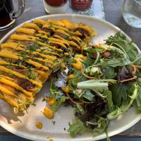 Chickpea Omelette with vegan sausage, vegan cheese, and mushrooms with side salad.  at Nourish Bistro in Banff