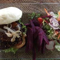 Hula burger: purple sweet potato fries, side salad, kitcheree burger patty topped with teriyaki sauce, caramelized onions, vegan mayo, tomato and lettuce. at Sage in Ubud