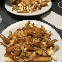 Gravy is vegetarian. Classic poutine on the back, Crispy poutine on the front. Vegetarian, not vegan.   at Poutineville in Quebec