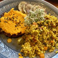Hamburger with carrot cream, brown Yamani rice, and potatoes  at Curcuma in El Chalten