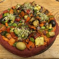 Pizza del Dragon - buckwheat and beetroot dough with vegies and olives on top with sunflower and cashew cheese. So delicious! But take note, this small one was quite substantial!  at Curcuma in El Chalten