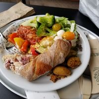 My friend's dinner - whole wheat roll, broccoli, cheese balls, potatoes, tomatoes, eggplant parmesan, strawberry rhubarb dessert... at Hiltl - Dachterrasse in Zurich