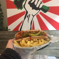 Spicy hot dog in front of the highly instagrammable wall art  at Orinoco Vegan York in York