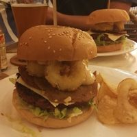 Burger with cheese, bacon and onion rings. at Green Bar in Makati