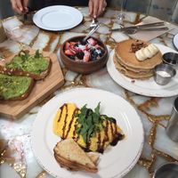 Brunch - avocado toast, coconut yoghurt fruit bowl, vegan pancakes, turmeric latte (ignore the omelette at the front which isn't vegan) at The Butcher's Daughter in Venice