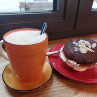 Cappuccino and pączek with cream. at Zielony Talerz x Wegałki in Krakow