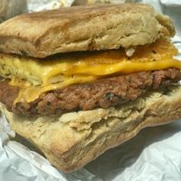 Yummy Biscuit sandwich: Housemade Biscuit, Housemade Sausage, Just Egg Patty, Cheese, Garlic Aioli (Contains Tree Nuts) 💚  at Reverie Cafe + Bar in Minneapolis