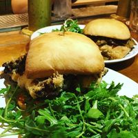 (Front) Fried Cauliflower Po Boy with smokey cashew remodelade, arugula and (Back) Berbere BBQ Sammie with housemade seitan, peppers, onions & garlic aioli. at Reverie Cafe + Bar in Minneapolis