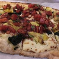 Creamy artichoke tomato basil crudo with garlic cashew cheese and spinach on gluten free (vegan!) crust at Double Zero in New York City