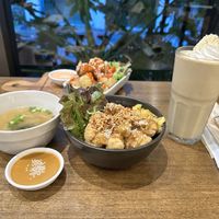 Background: Fried cauliflower wings with accompanied sauce (appetizer). Foreground: Teriyaki bowl with miso soup and peanut sauce & a banana smoothie with coconut whip cream 😋 # at Veganerie Concept - Benjasiri Park in Bangkok