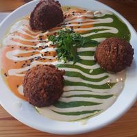 Colorful Hummus (parsley paste and garlic tomato paste) with falafel at The Hummus of Tahini in Jerusalem