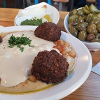 Hummus mixed with Tahini and falafel (plus olives, pickles, onion, and a little spice in the back) at The Hummus of Tahini in Jerusalem
