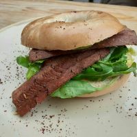Facon bagel with roasted cherry tomatoes, spinach and salsa verde at Hyde Park Book Club in Leeds
