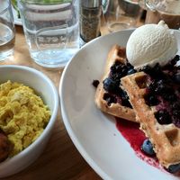 The vegan quinoa oat and blueberry waffles with maple syrup and ice cream, "sausage," and tofu scramble. at Mildreds - Kings Cross in North London
