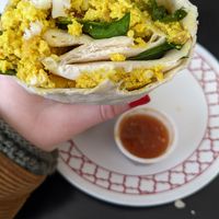 Tofu scramble breakfast burrito with hot sauce at Elemental Coffee in Oklahoma City
