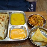 Stuffed Paratha with sides of onion bhaji and samosa at Thenga Cafe in London