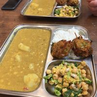 Vegetable dahl, rice, onion bhajis and a cold chickpea salad at Thenga Cafe in London
