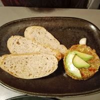 Avocado tartar served with bread and a clove of garlic. at Vegan's Prague in Prague