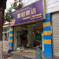 New sign outside. at Jù Cái Sù Diàn in Tibet