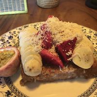 Vegan French toast with bananas, passion fruit and dragon fruit. Topped with coconut shavings.  at Simple Things in Kampot