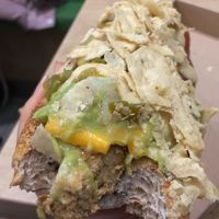 Mexican hot dog! Lettuce, tofu sausage, cheese, guac, sauce, crumbled tortilla chips  at Vegan Love in Budapest