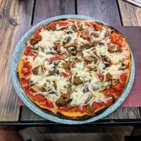 Pizza with vegan cheese and sausage at Rifugio Romano in Rome