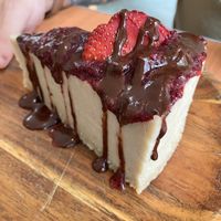 Traditional cheesecake with berry sauce, and chocolate sauce on top at Cafe Wylde in Everett