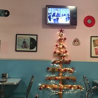 Old TV shows and commercials are show in their original black and white on a new tv made to look like an old tv. Christmas tree because it is the season right now. at Comet 984 in Playa Del Carmen