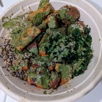 Brown rice quinoa base, kale, sweet potatoes, lentil meatballs, toasted coconut, corn fritters with walnut pesto herb green sauce at Della Bowls in Miami